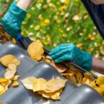 cleaning out clogged gutters from a roof